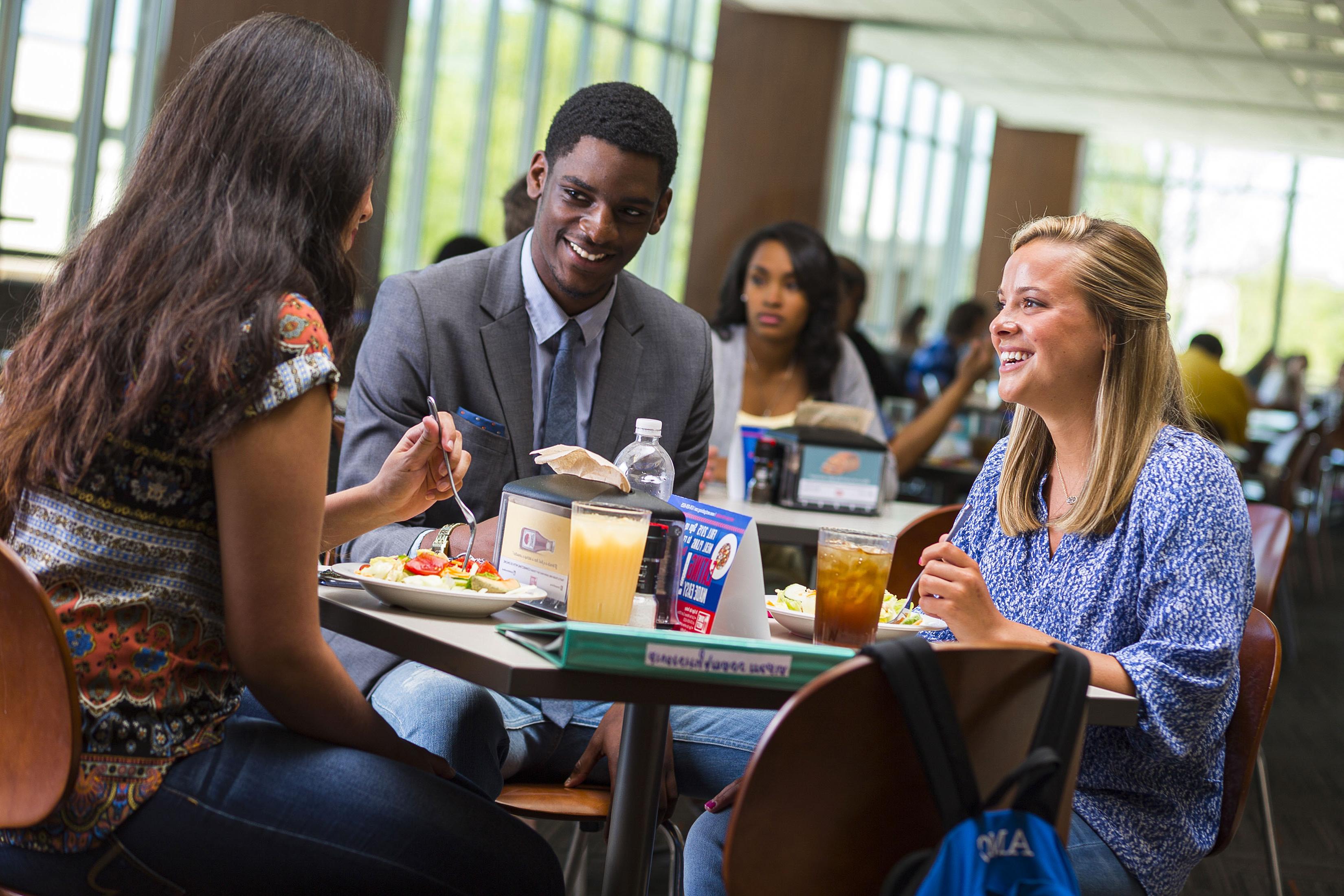 People sitting at table in dining hall. 